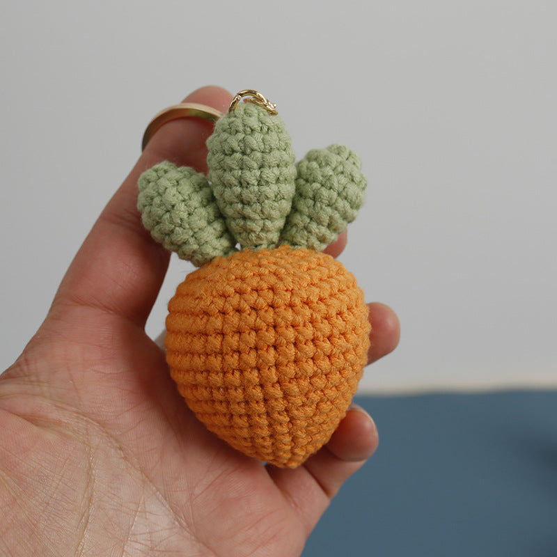 Handmade crochet carrot keychain hanging on a bag