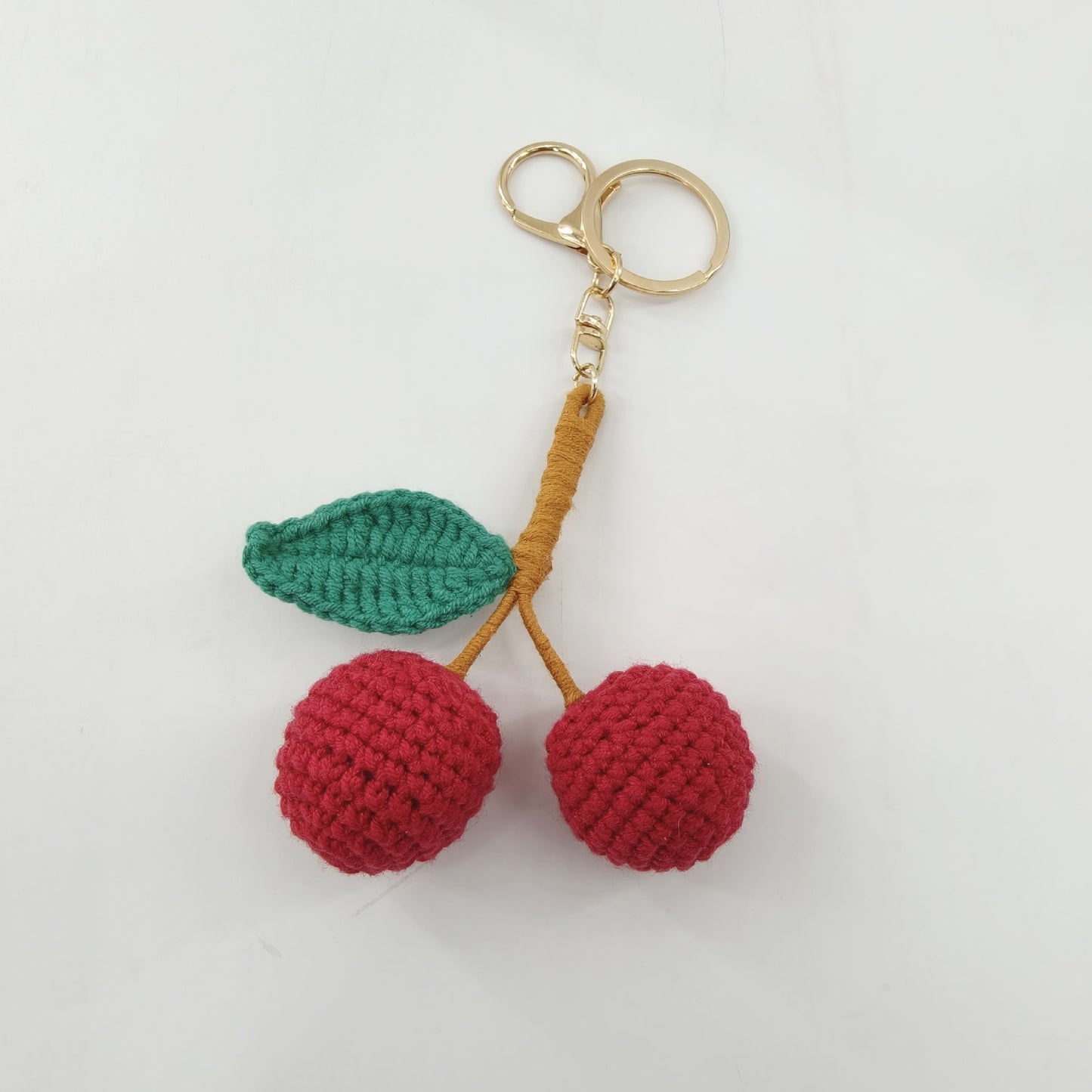 Single crochet cherry keychain displayed as a cute handmade bag charm and decorative accessory
