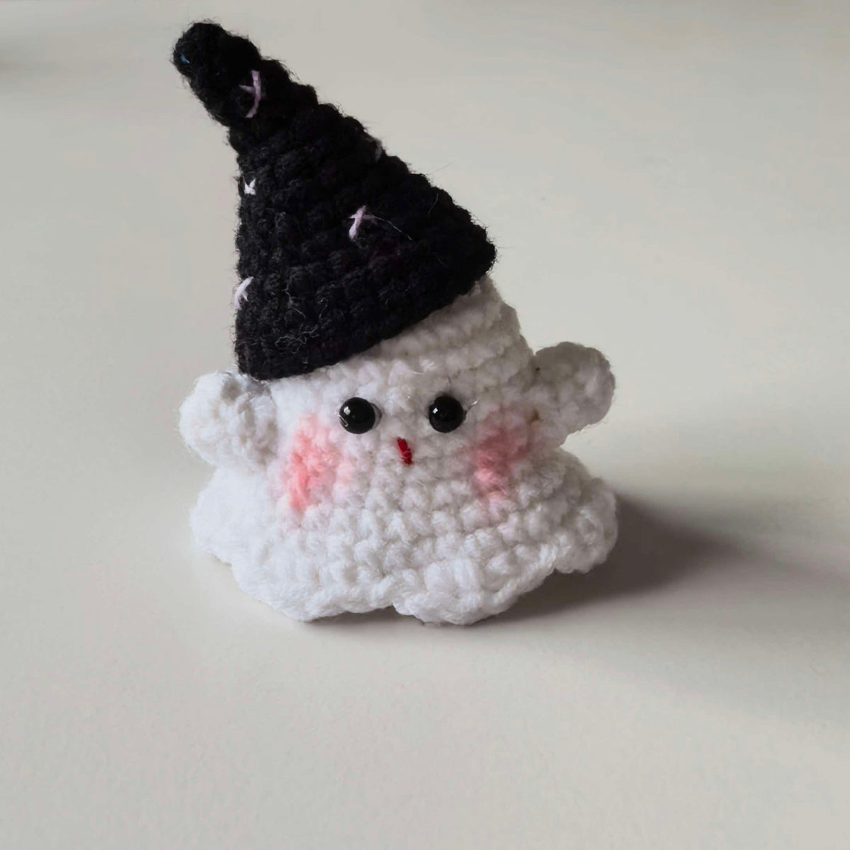 Cute mini crochet Halloween witch plush with witch hat, perfect for a keychain or bag charm