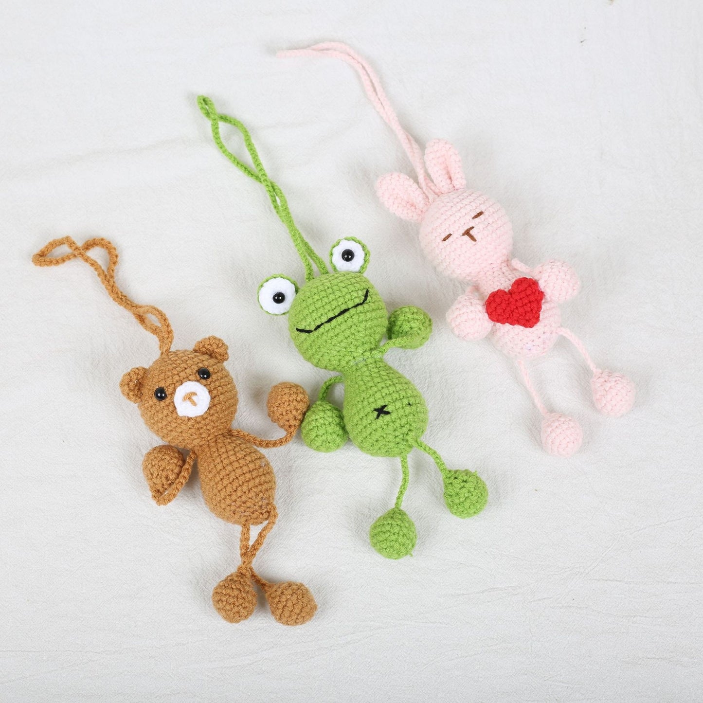 Crochet animal kit featuring frog, bunny, and bear finished plush keychains with hanging legs