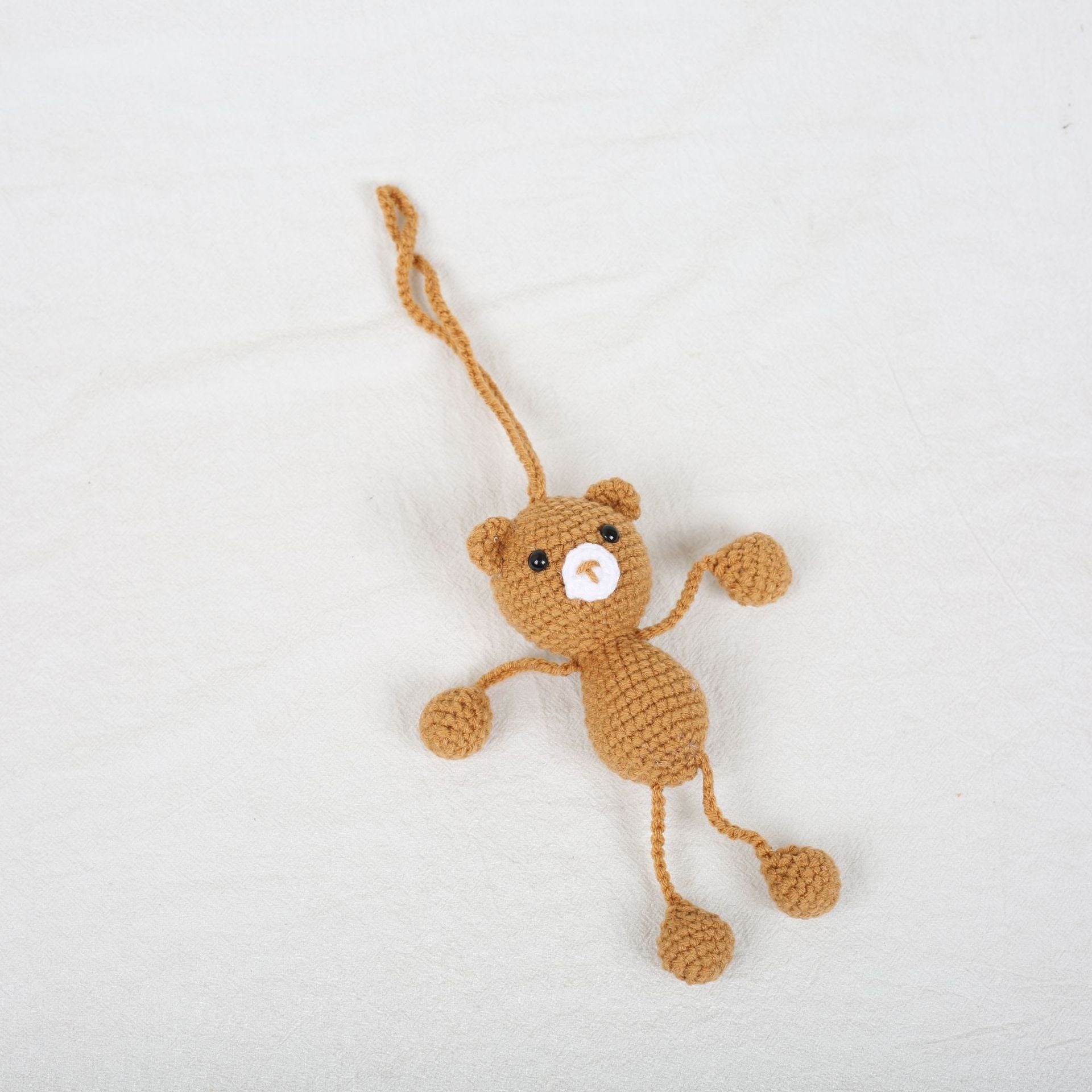 Adorable crochet bear plush keychain with long hanging legs made from DIY crochet kit