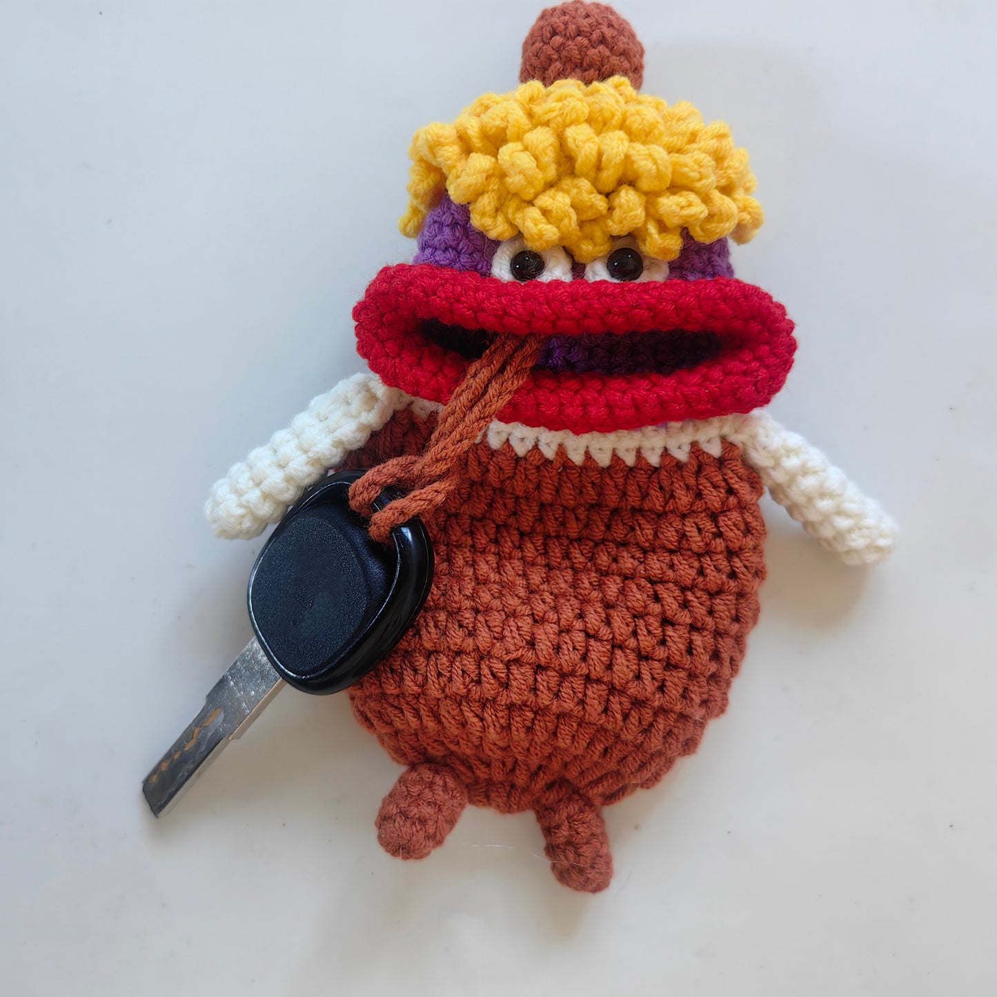 Close-up view of cute crochet big mouth key cover with handmade details