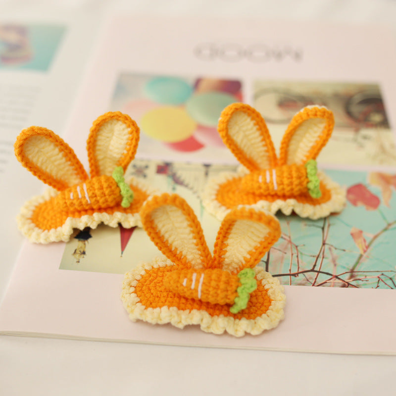 Close-up detail of handmade orange crochet bunny hairclip showing carrot accent and metal clip backing