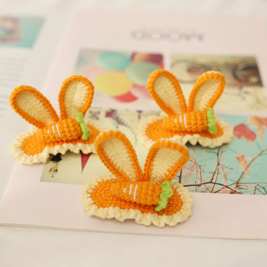 Close-up detail of handmade orange crochet bunny hairclip showing carrot accent and metal clip backing