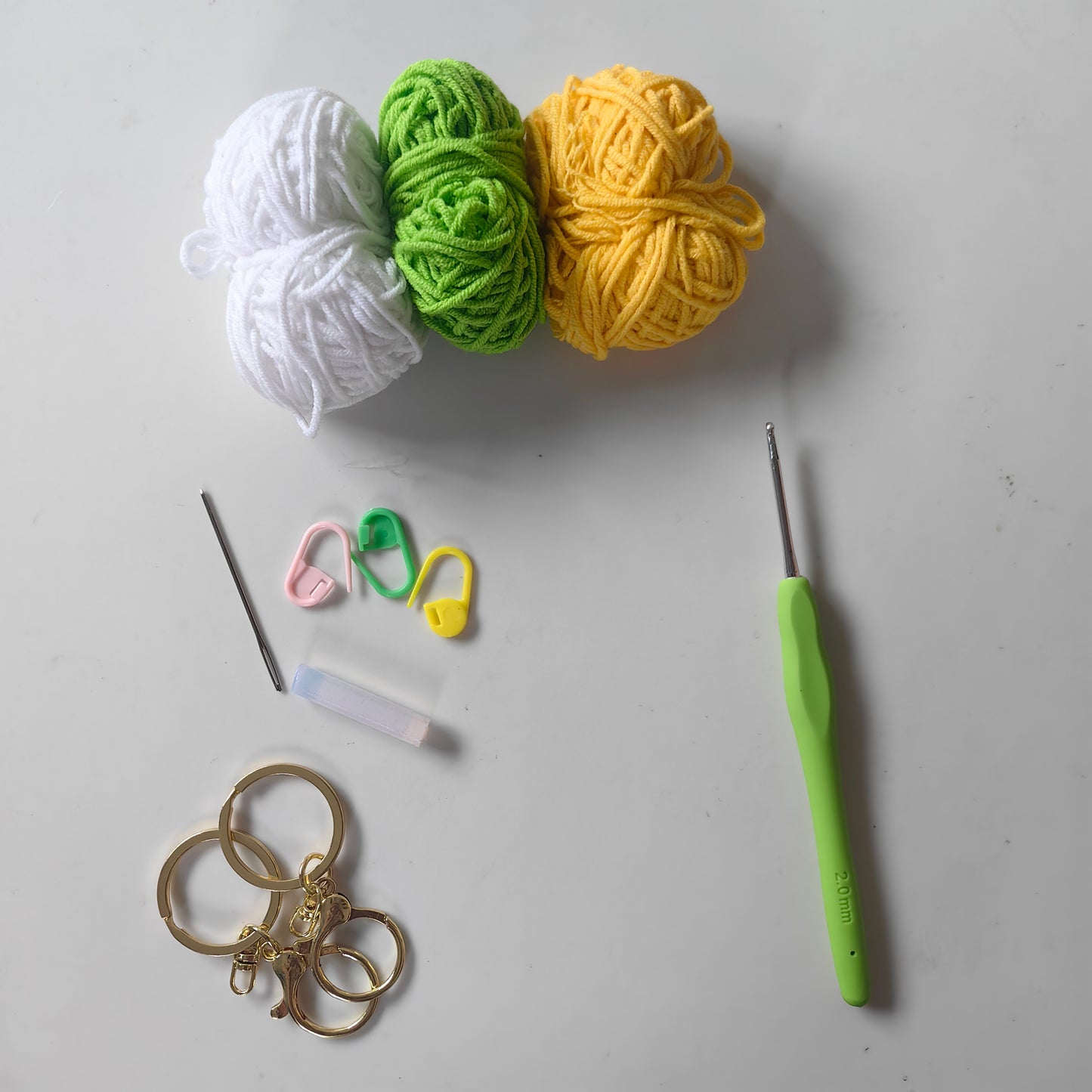 Crochet cabbage kit materials including yarn, crochet hook, stuffing and accessories for DIY project