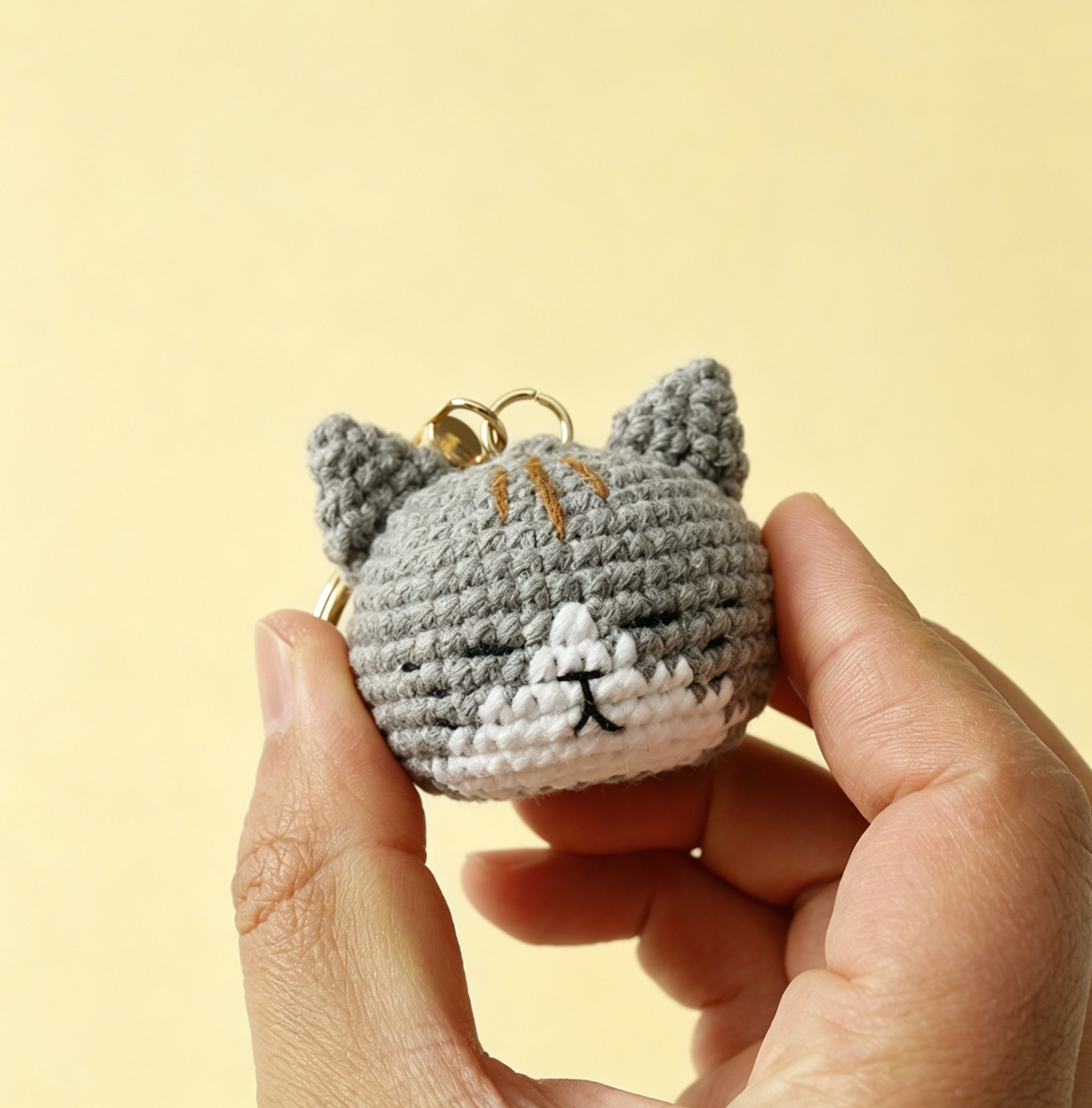 Cute gray crochet cat plush keychain handmade from yarn, adorable amigurumi cat charm for bags, keys, and gifts.