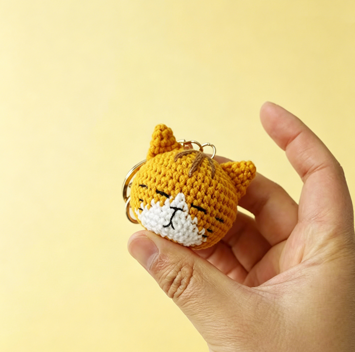 Cute yellow crochet cat plush keychain handmade from yarn, small amigurumi cat decoration approximately 5cm tall