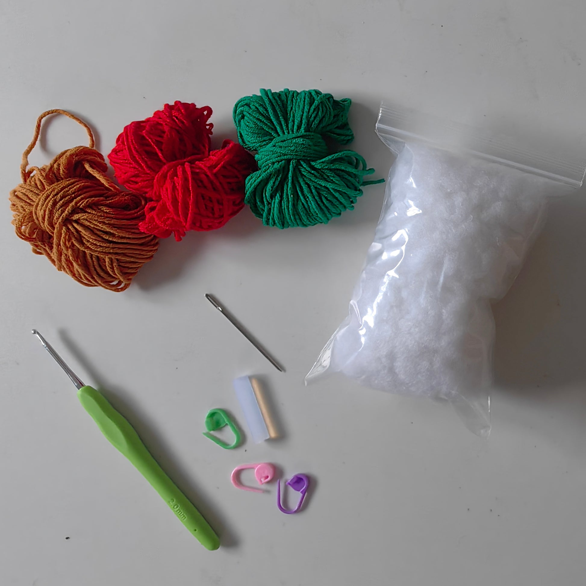 Complete crochet cherry keychain kit with yarn, stuffing, crochet hook, accessories, and materials for making three cherry keychains