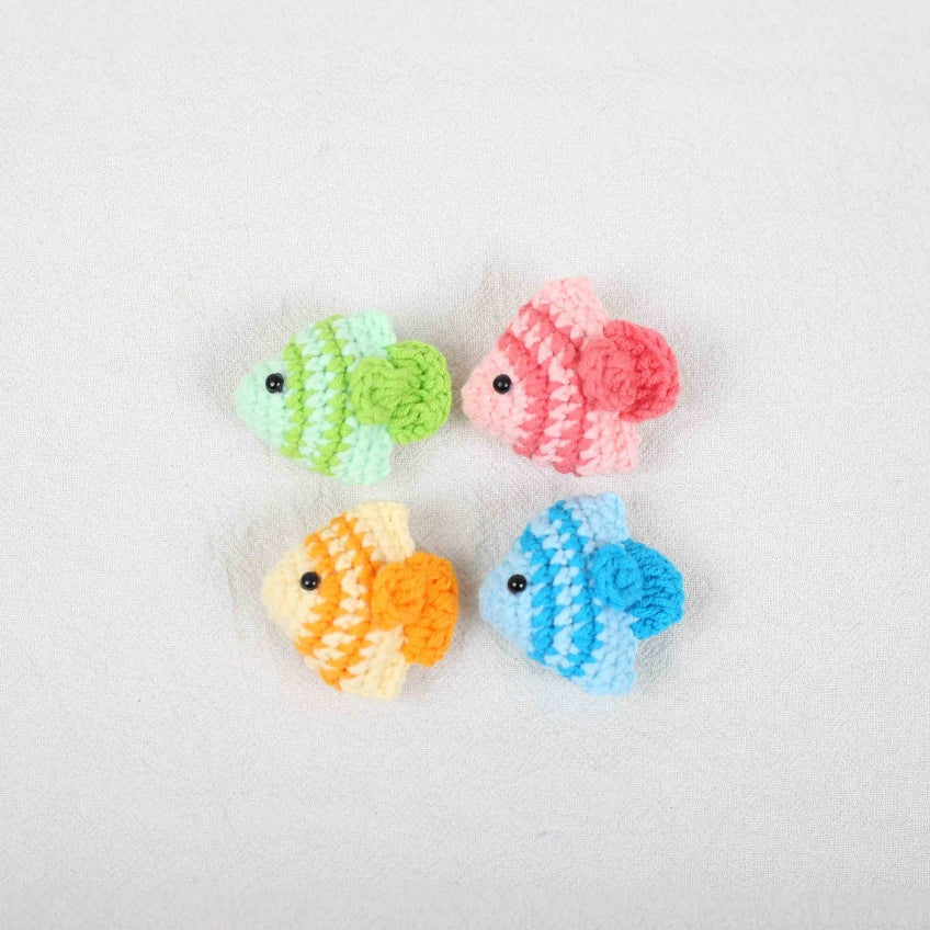 Close-up detail view of handmade crochet fish plushies showing soft texture,