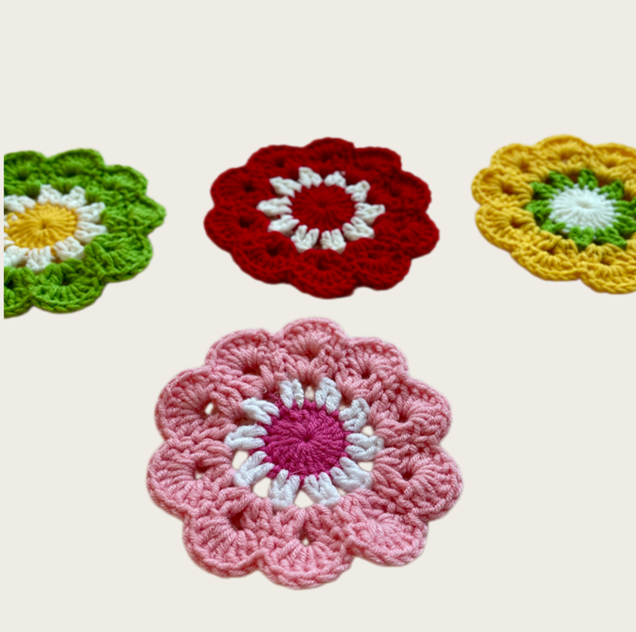Handmade crochet flower coasters in five colors displayed from an angled perspective for home décor inspiration