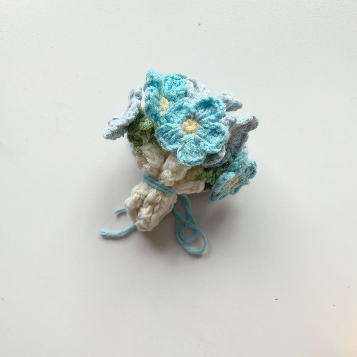 Crochet forget-me-not coaster folded into a cute flower bouquet