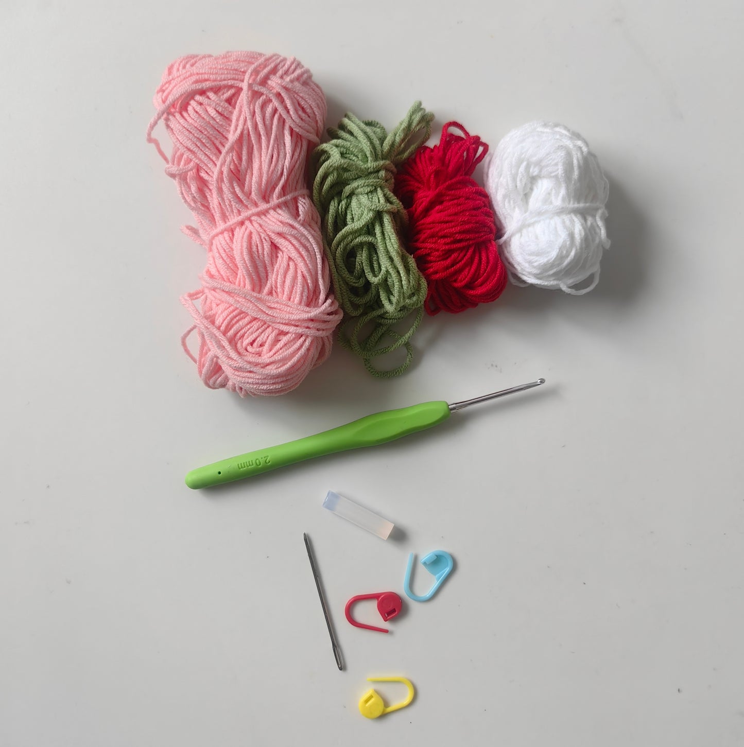 Complete crochet fruit drawstring pouch kit materials including yarn, crochet hook, accessories, and tutorial supplies