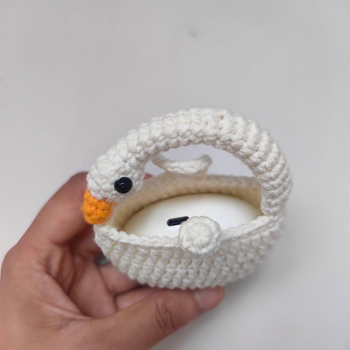 Crochet goose earphone case holding wireless earbuds
