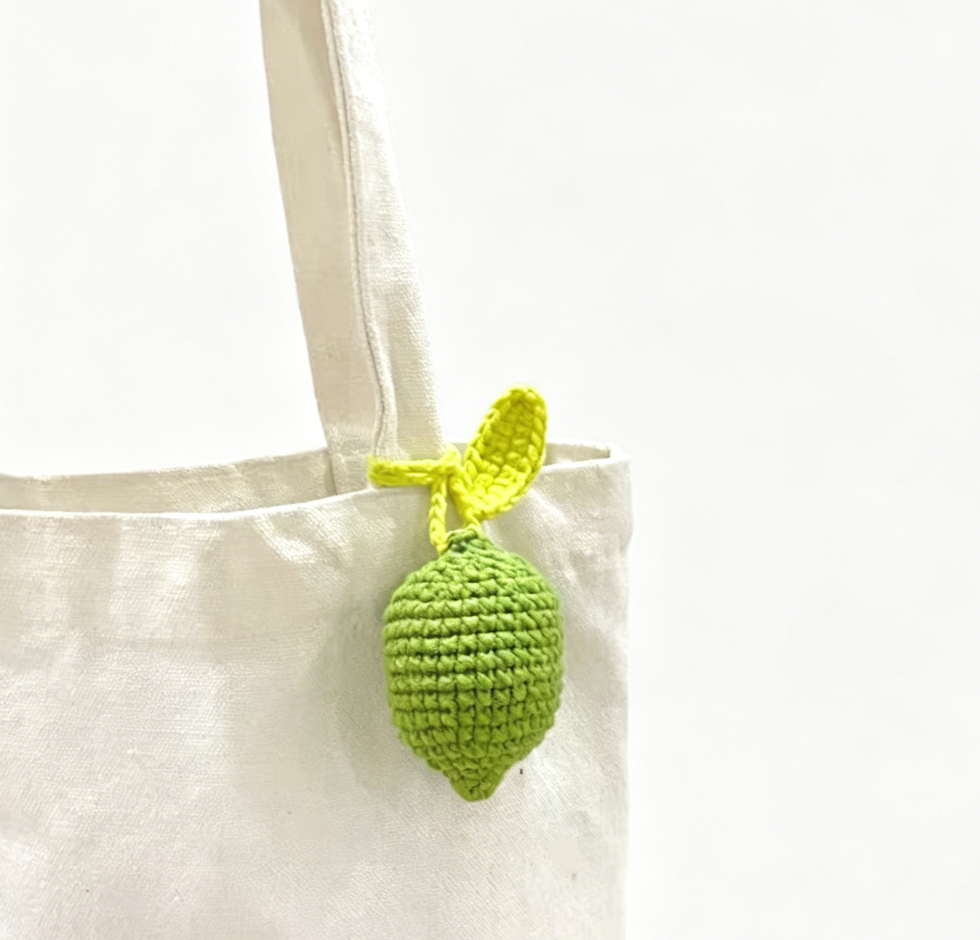 Close-up of a green crochet lemon plush featuring neat crochet stitches