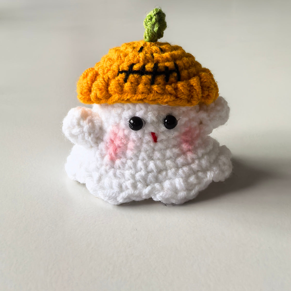 Cute mini crochet Halloween pumpkin plush with pumpkin hat, perfect for a keychain or bag charm