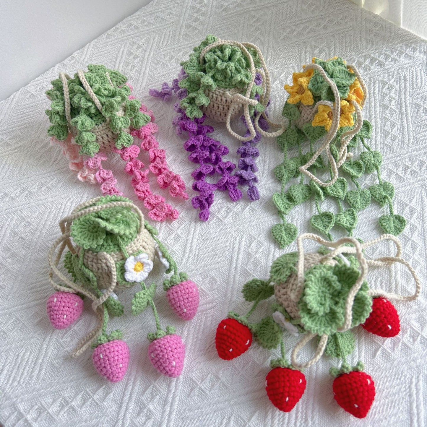Five crochet hanging basket decors displayed together on a table