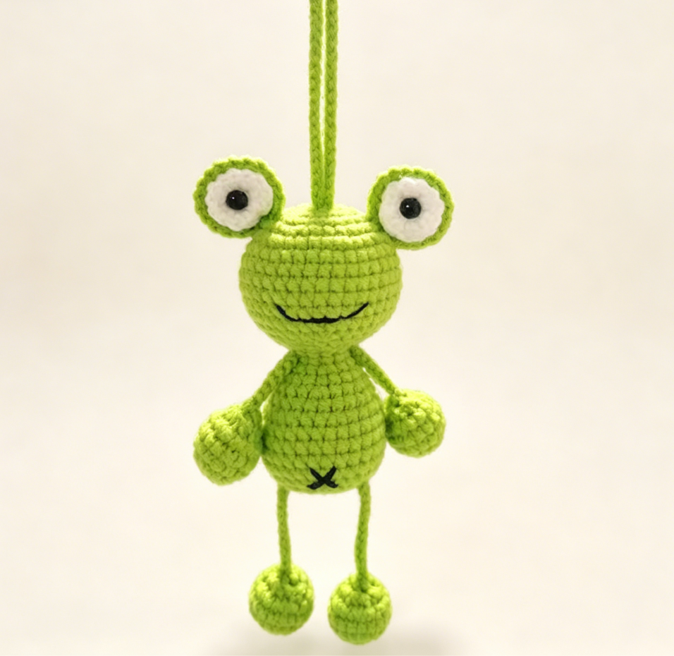 Two crochet hanging frog keychains detail view showing handmade texture and adorable details