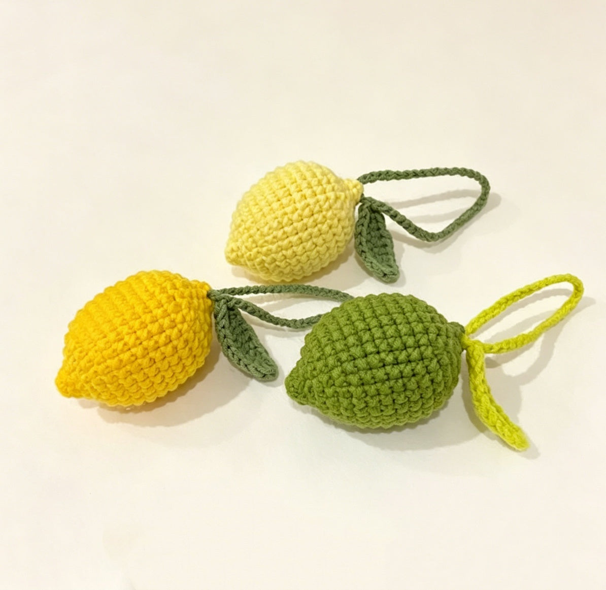 Three colorful crochet lemon plushies made with the crochet lemon kit
