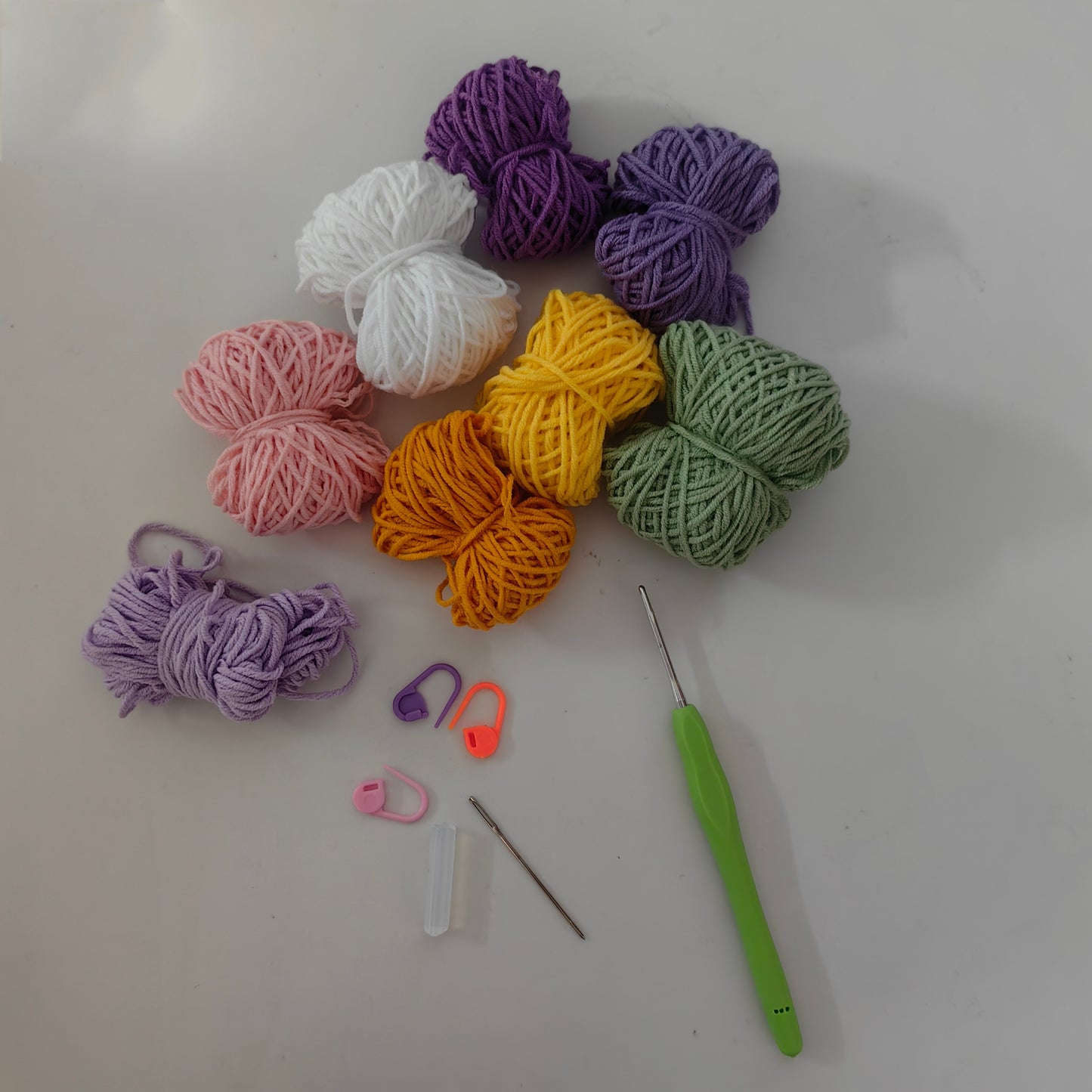 Complete Crochet Lily Coaster Kit materials including yarn, crochet hook, accessories, and crafting tools.