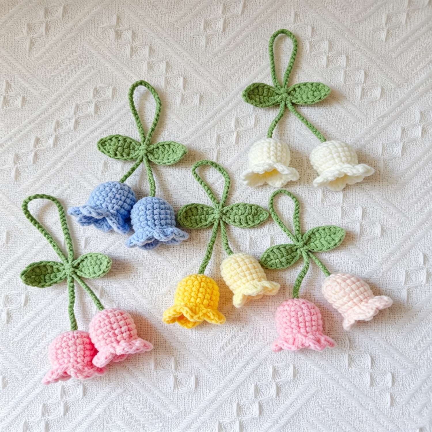 Five colorful crochet Lily of the Valley flower keychains together