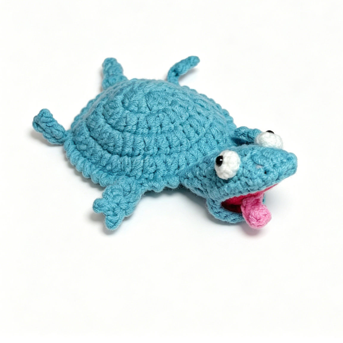 Close-up detail of a handmade crochet lizard coaster with textured stitches and cute design
