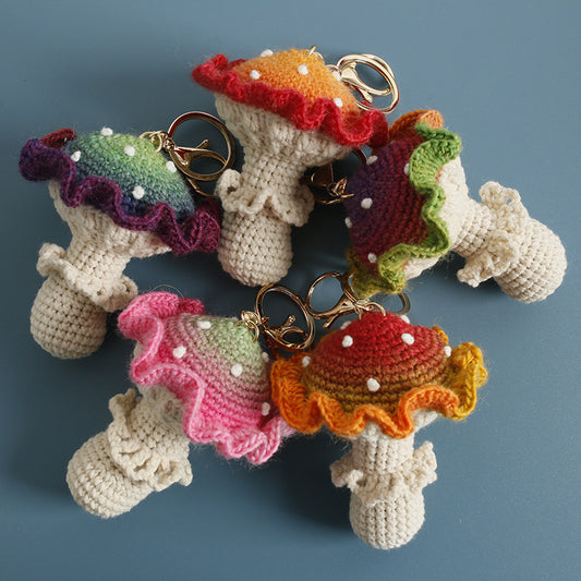 Five crochet mushroom keychains in different colors displayed together