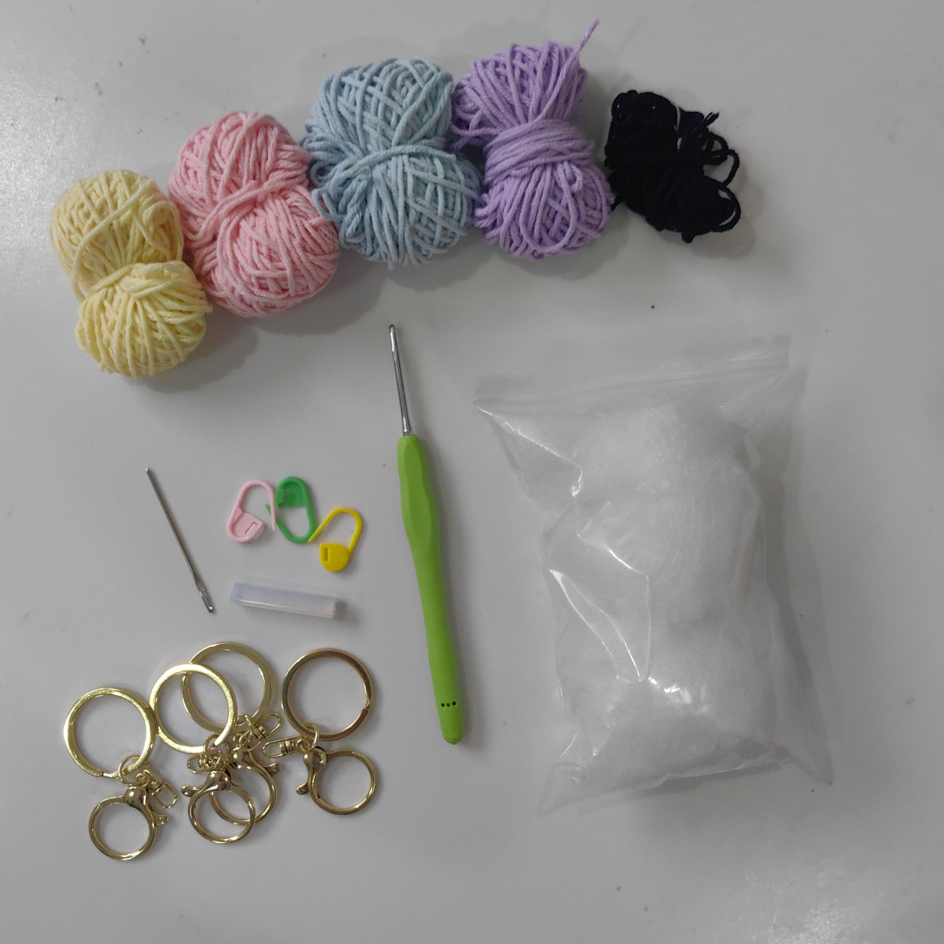 Crochet octopus kit materials including yarn, stuffing, safety eyes, keychain hardware and accessories