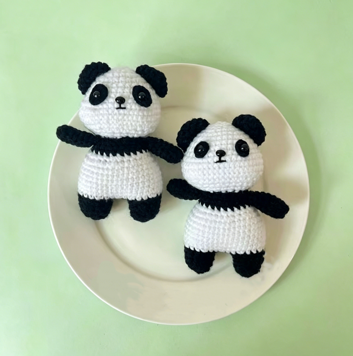 Close-up detail of handmade crochet panda plush showing cute facial features, stitching details, and soft yarn texture