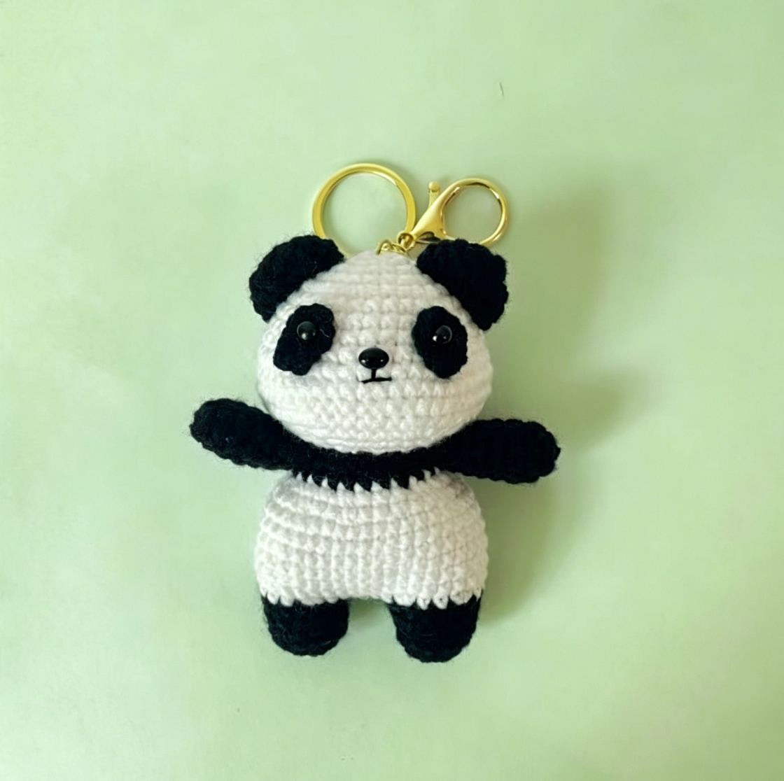 Single crochet panda plush attached to a keychain ring, cute handmade panda bag charm and key accessory.
