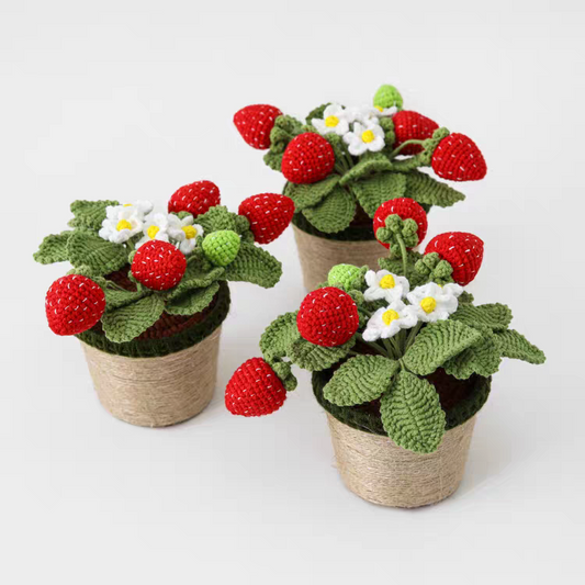 Three handmade crochet strawberry plants in jute-wrapped pots