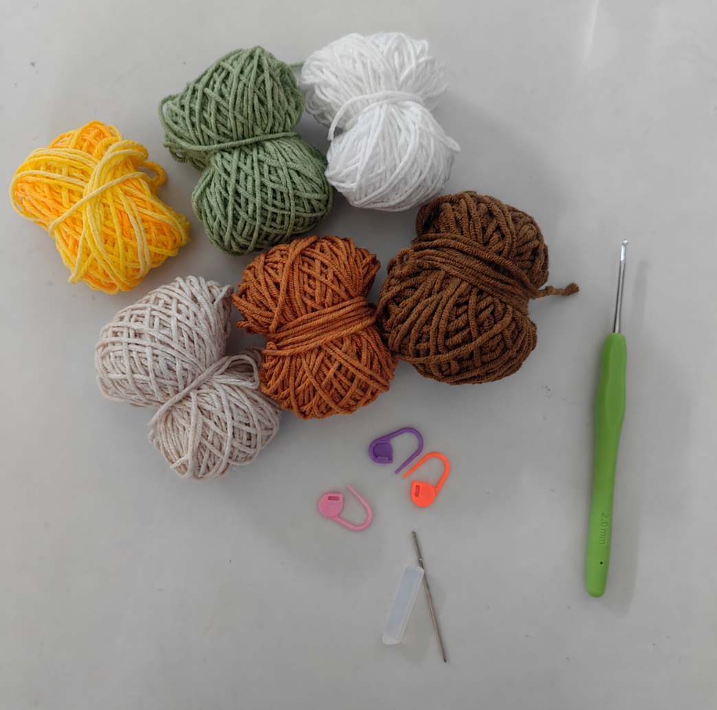 Complete crochet sunflower pouch kit materials including yarn, crochet hook, accessories, and instructions