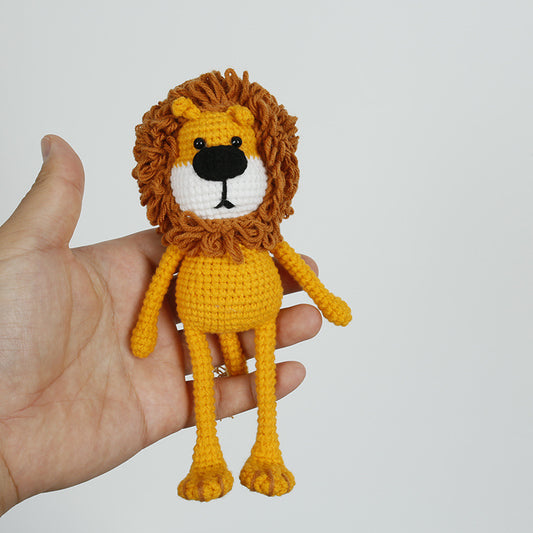 Handmade crochet lion plush held in hand for size reference
