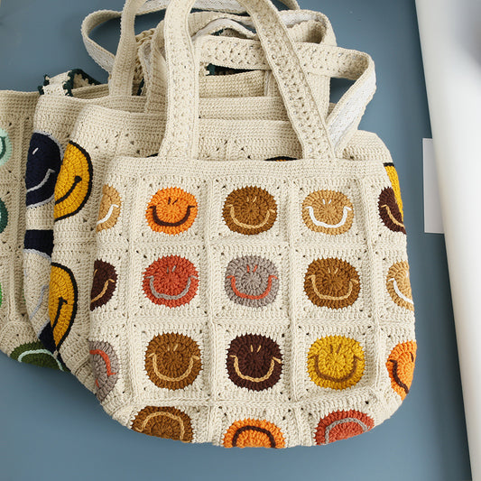 Handmade smile crochet tote bags in four colors displayed together